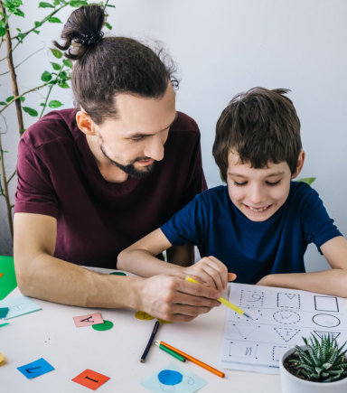 man teaching young kid with shapes
