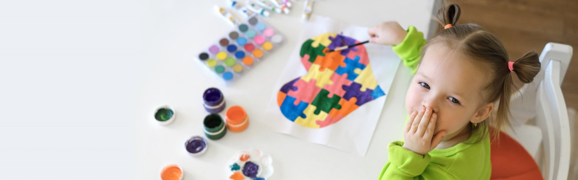young kid coloring a heart puzzle