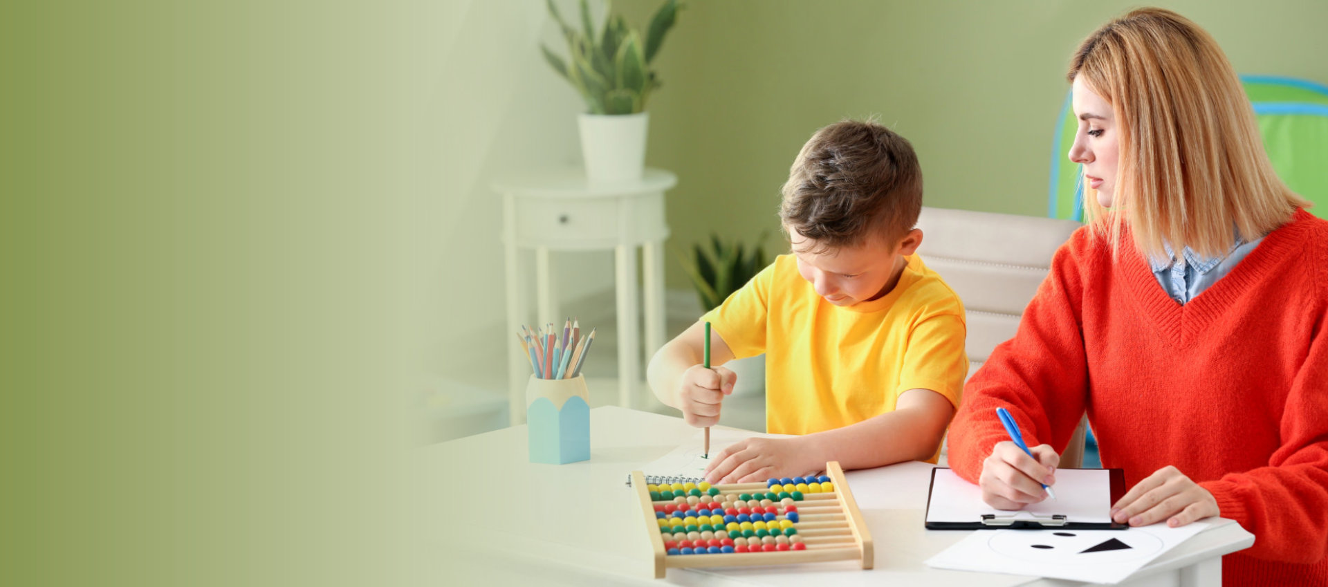 woman with young kid drawing using color pencils
