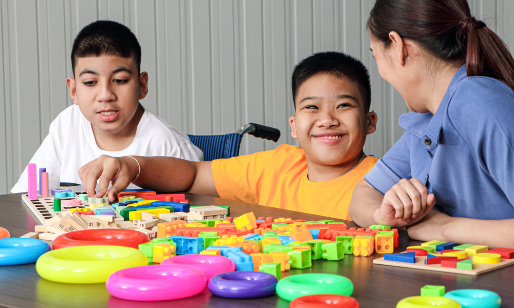 two kids and a woman playing blocks