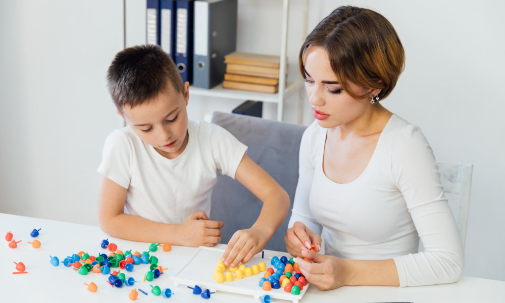 woman with young kid forming letters