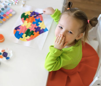 young girl kid painting puzzle heart
