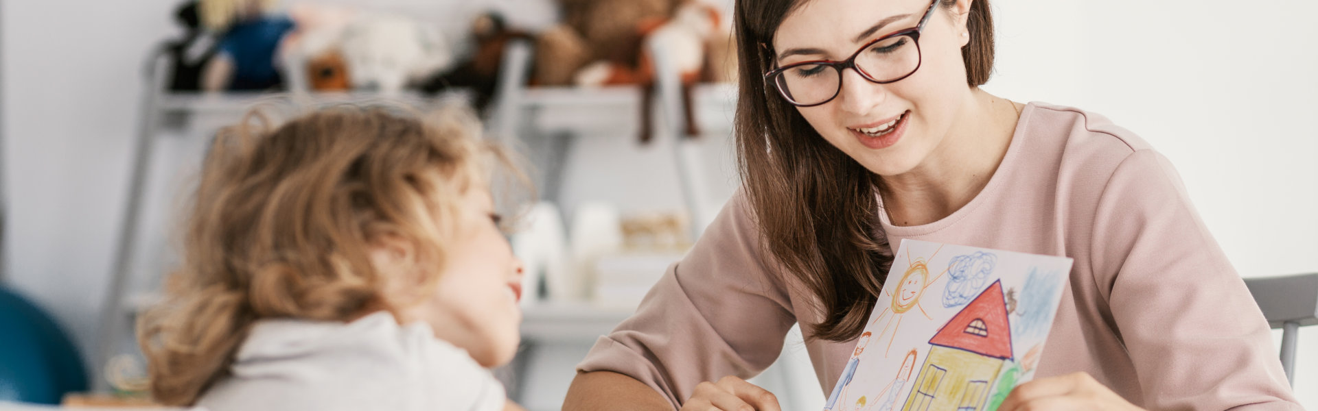 woman showing a drawing to young girl