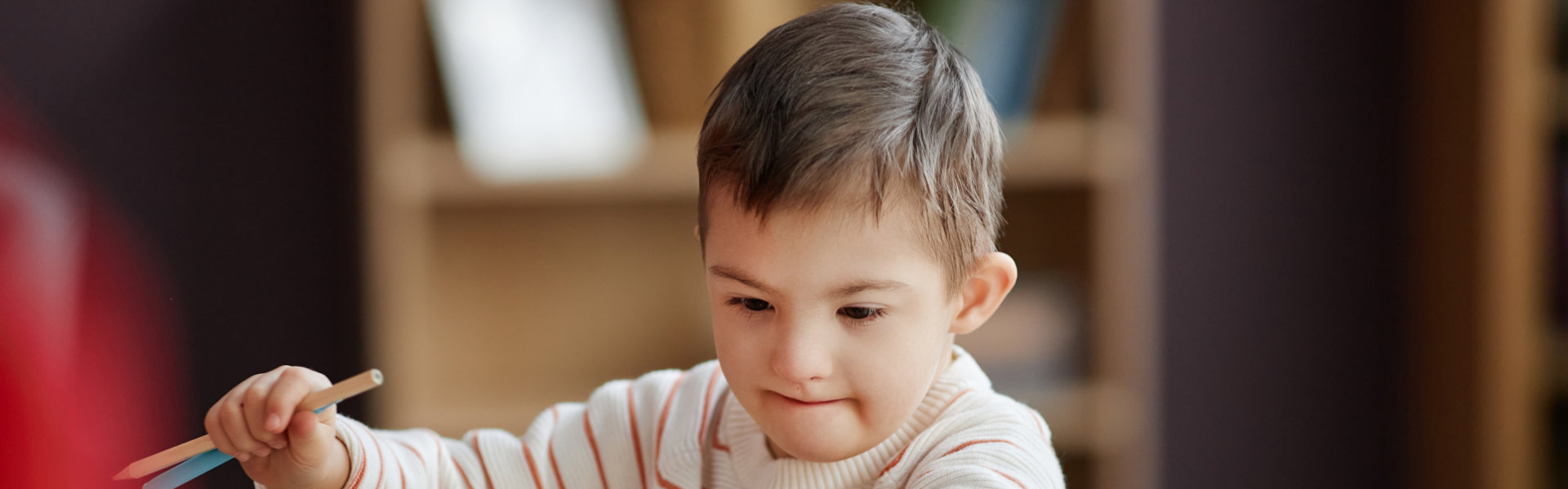 young kid holding color pencils