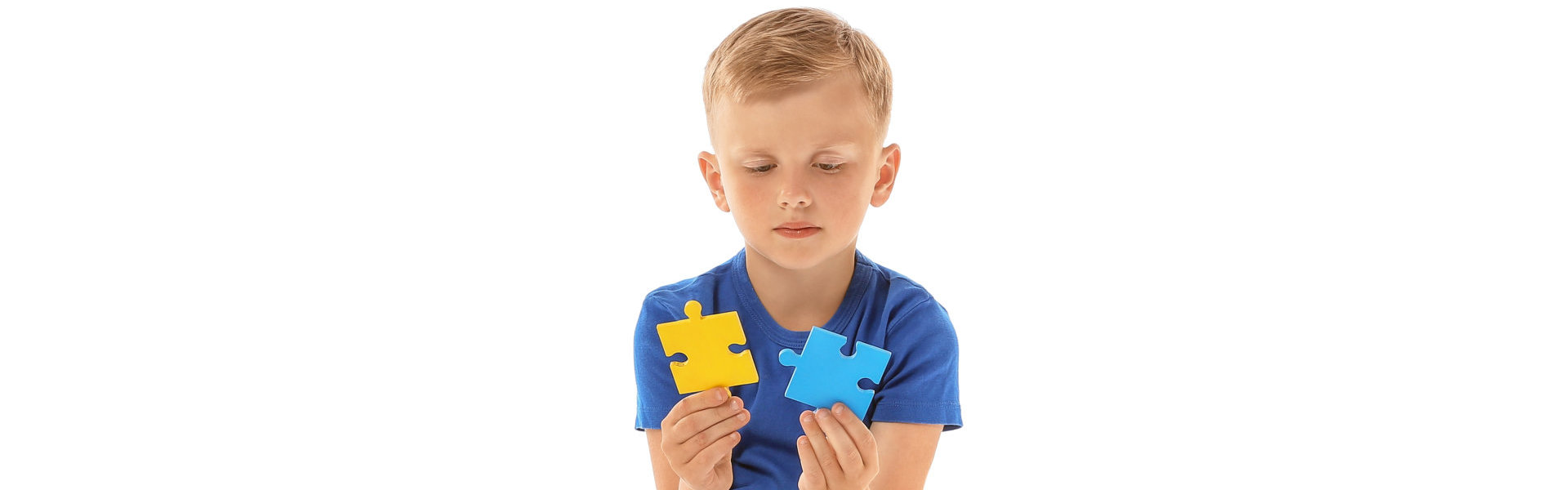 young kid wholding two puzzles